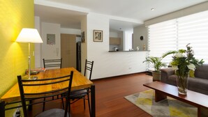 A dining area with a wooden table and chairs, a lamp, and a dining table with a rug. - Spacious, modern, GREAT LOCATION netflix, wifi, cable, 2BEDROOM, 2BATHROOM (La Carolina)