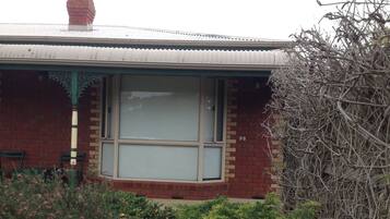 Stunning residential building with a brick facade, large window, and charming green trim.