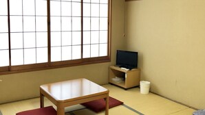 A room with tatami mat flooring, a wooden table, a television on a low stand, and a window with a grid pattern. - Resort Inn Fujihashi (Fujikawaguchiko)