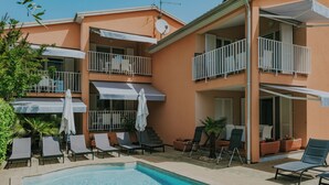 A two-story building with balconies, a swimming pool, and outdoor seating areas. - Villa DANEX STANDARD **** (Umag)