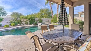 An outdoor patio with a pool, a round table, and chairs. - 6 Mi to Coachella: Updated Home w/ Pool & Spa (Indio)