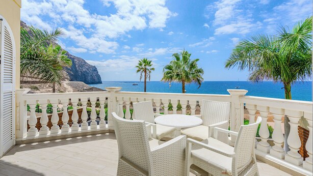 A balcony with white wicker furniture, a view of the sea, and palm trees. - ..it's your place!... (Los Cristianos)