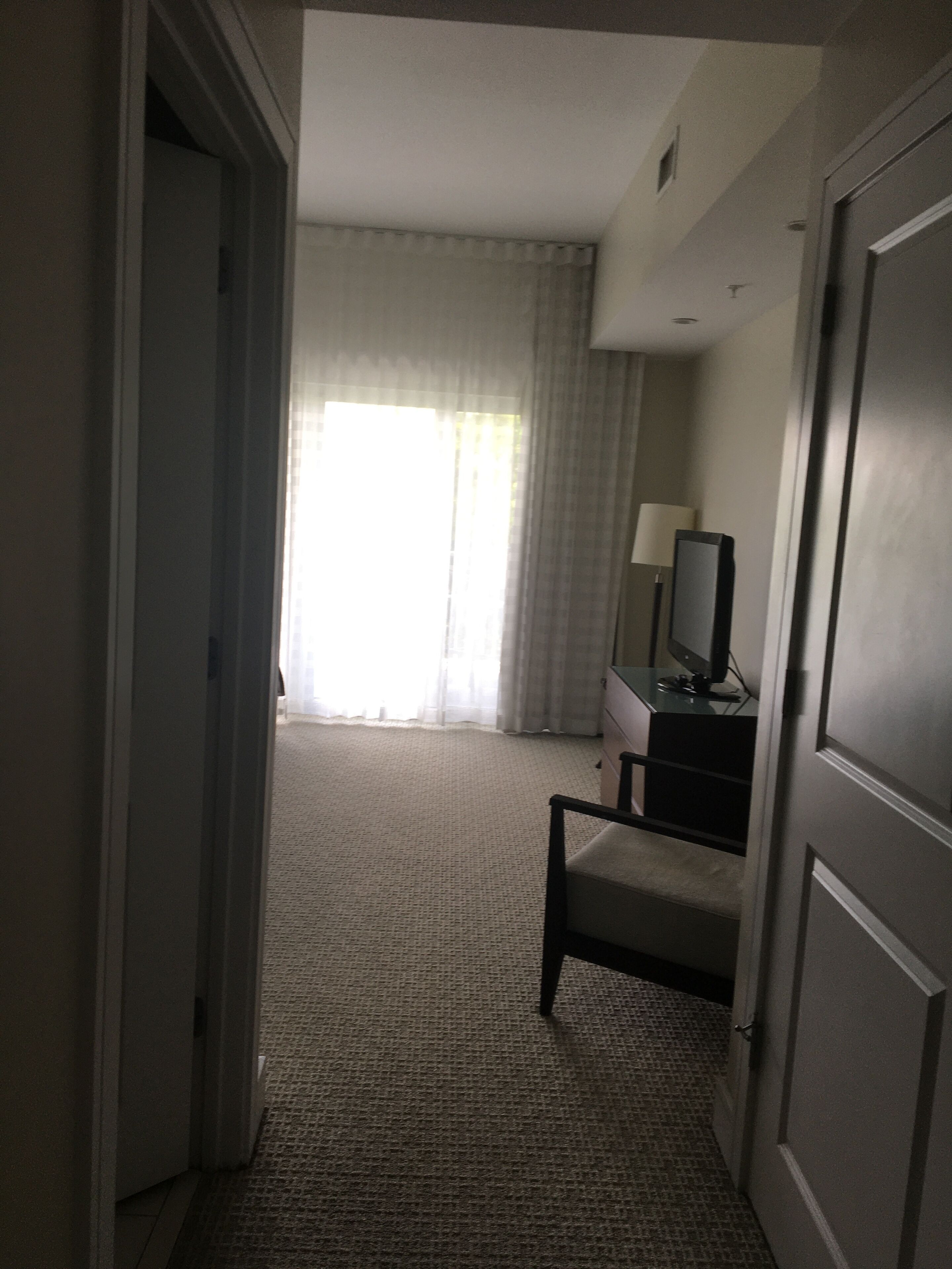 Une chambre d’hôtel équipée d’un lit, d’un bureau, d’une chaise, d’une lampe et d’un téléviseur.