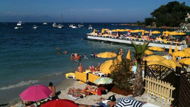 Une plage avec des parasols jaunes et des gens qui se détendent.