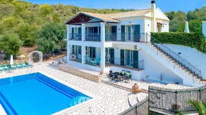 A two-story building with a swimming pool, outdoor seating, and a staircase leading to the upper floor. - Villa di Giovanni -  Villa Rental in Peritheia, Corfu, Greece (Peritheia)