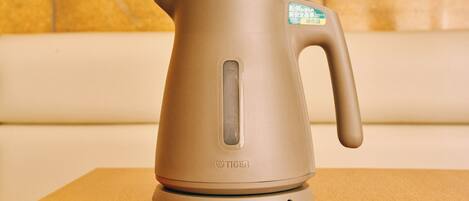 A kettle on a table with a label on the handle.