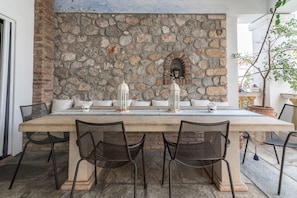 A stone wall with a built-in bench and a small alcove with a lantern. - Villa SEAlia Elegantseasidein Spetses (Spetses)