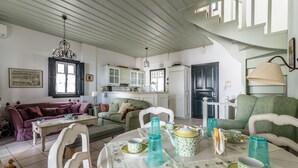 Una sala acogedora con una mesa de comedor dispuesta para el té, un sofá y una cocina al fondo.