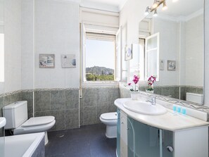 Een bad, een haardroger, handdoeken, toiletpapier