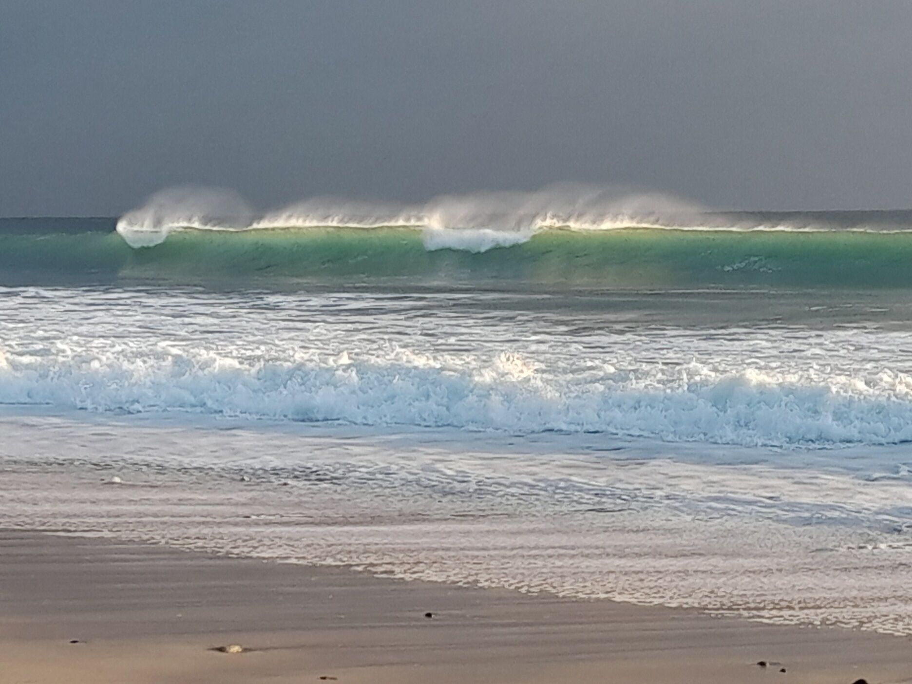 A beach with waves crashing onto the shore.