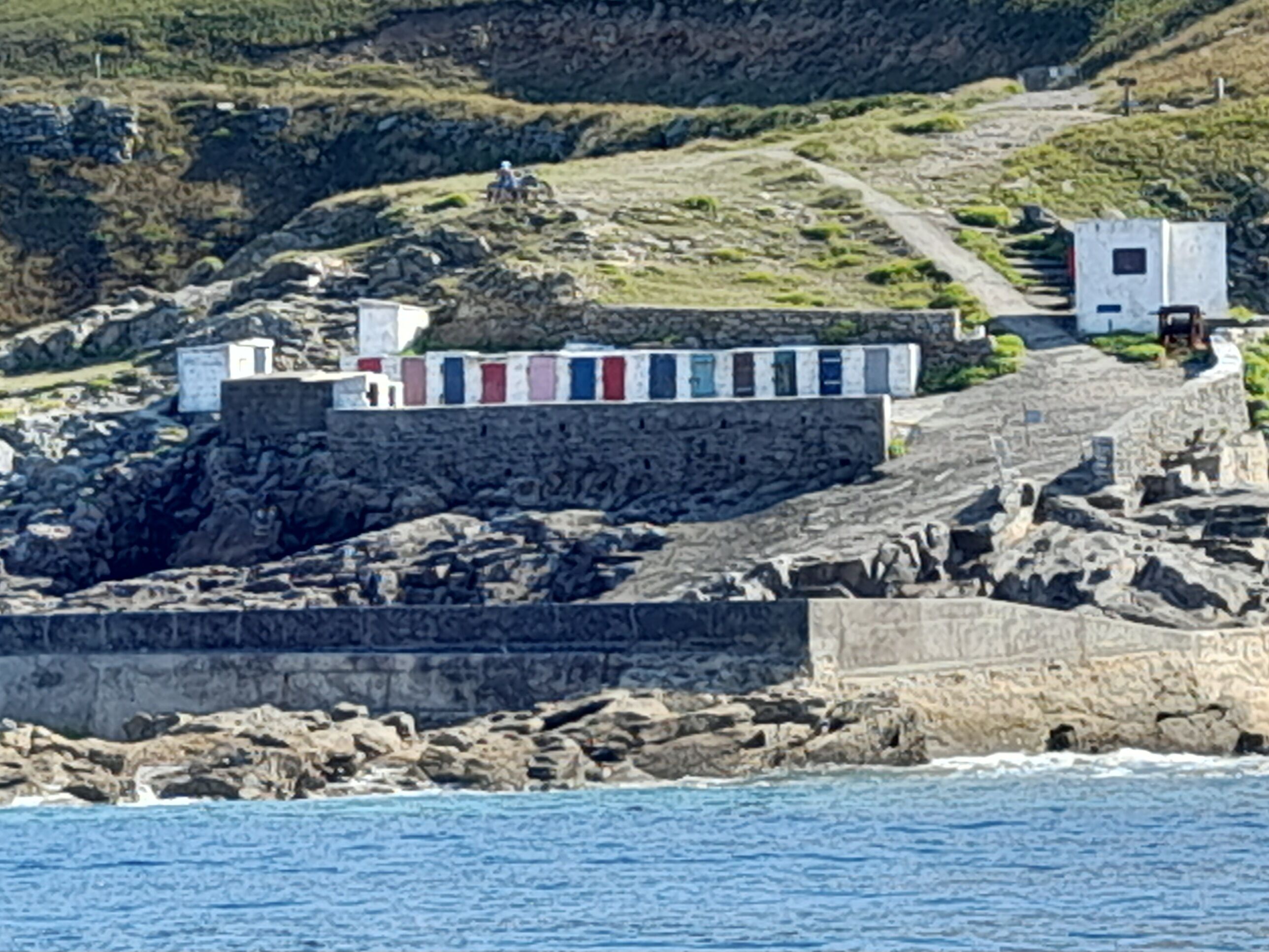 A coastal building with a stone wall and a flag display.