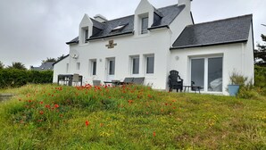 Un bâtiment blanc doté de nombreuses fenêtres et d’un toit en pente.