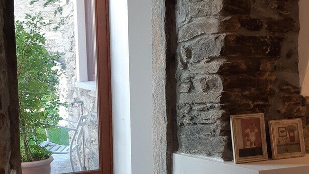 A stone archway leading to a balcony with a view of greenery and a bicycle. - Camellia, suggestions between Lake and mountains (Premeno)