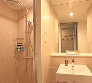 A modern bathroom with a walk-in shower, a sink, and a mirror. - Urban Hotel Kyoto Shijo Premium (Kyoto)
