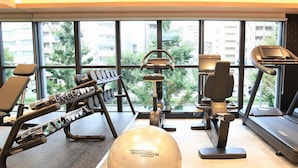 A gym with exercise equipment, a large exercise ball, and a treadmill. - Urban Hotel Kyoto Shijo Premium (Kyoto)