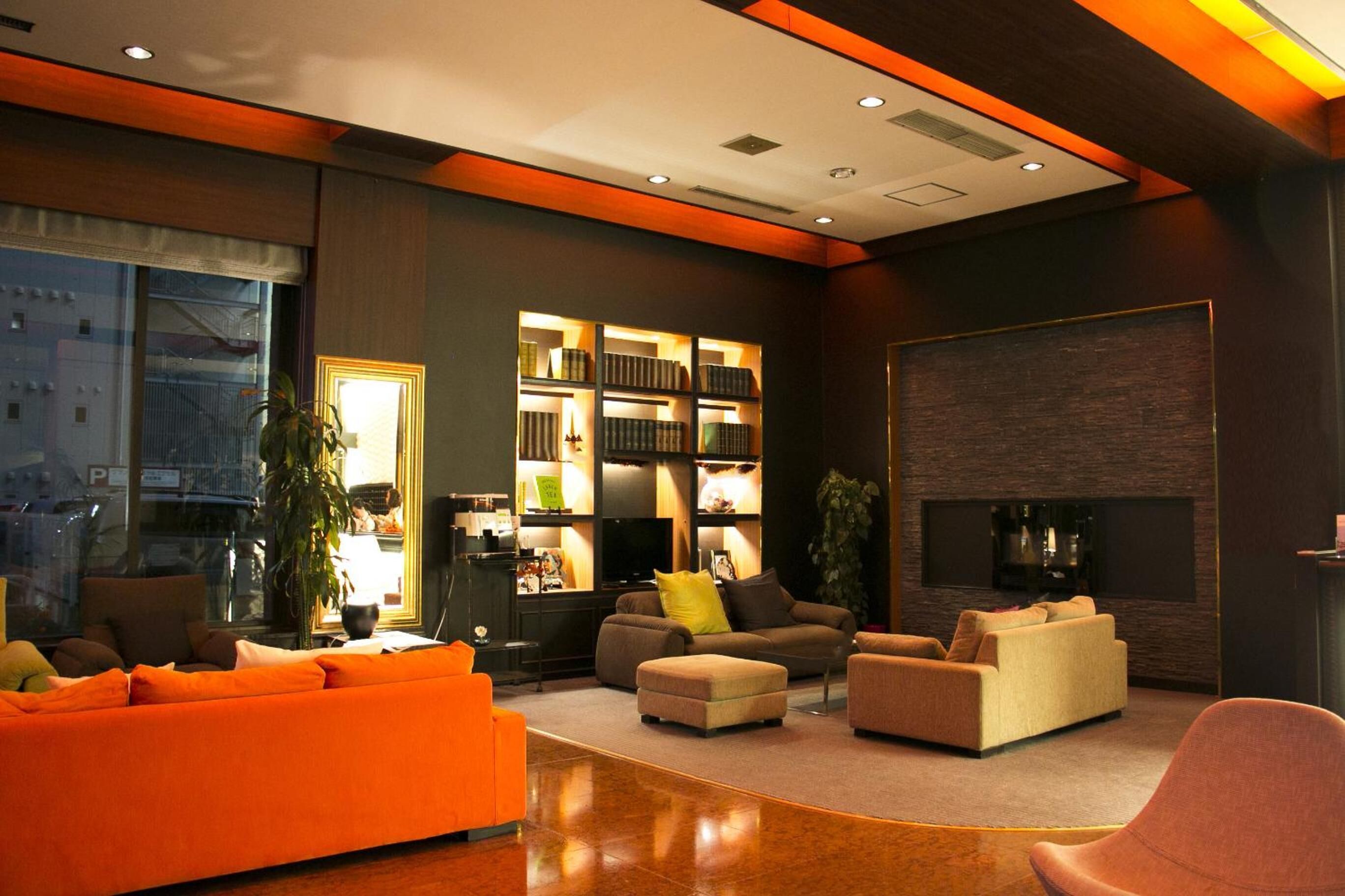 A modern living room with a fireplace, a bookshelf, and a large window.