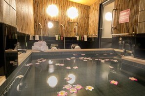 Un bassin de spa agrémenté de nénuphars et doté d’un intérieur en bois.