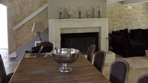 A dining area with a large wooden table, a chandelier, and a fireplace. - Magnificent Bastide in the heart of alpilles, quiet absolute, exceptional position, private Tennis, Swimming pool warmed 7 rooms 4 bathrooms (Fontvieille)