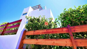 Um edifício branco com uma cerca de madeira em primeiro plano.