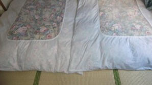 A bed with floral-patterned pillows and a woven floor mat. - Nakano (Fujiyoshida)