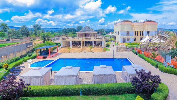 Um hotel com uma piscina grande, área de estar ao ar livre e um jardim bem cuidado.