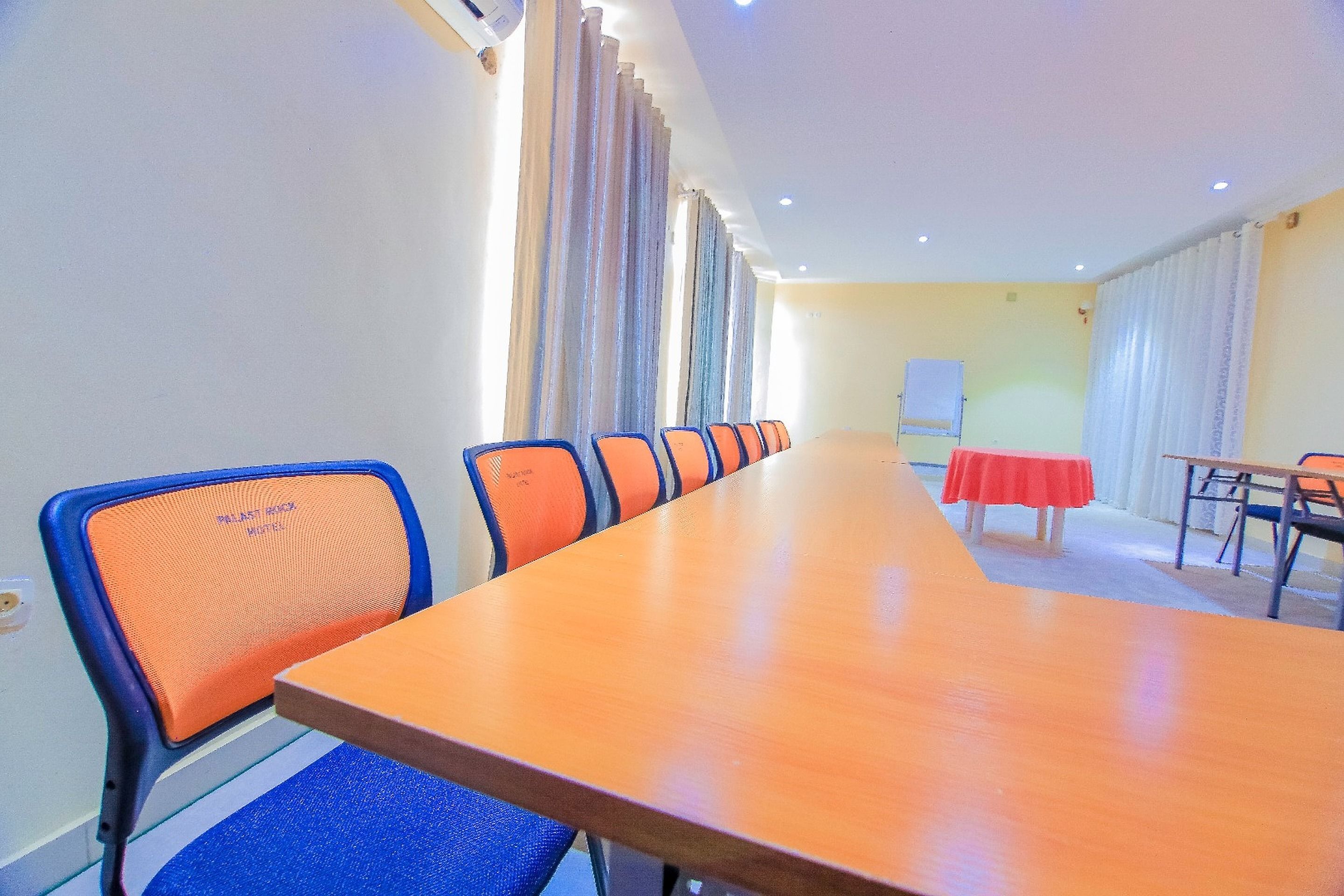 Una sala de conferencias con una larga mesa, varias sillas y una pizarra.