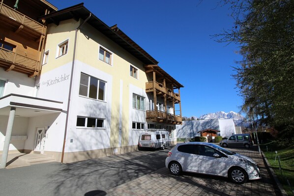Un edificio de varios pisos con un cartel que dice "Haus Kitzbichler".