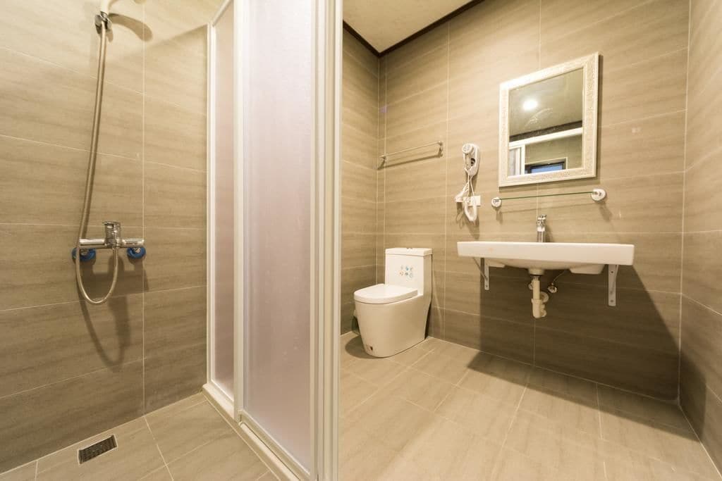 A modern bathroom with a shower, toilet, and sink.