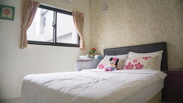 Una cama bien hecha con ropa blanca, cabecera y un peluche de Mickey Mouse.