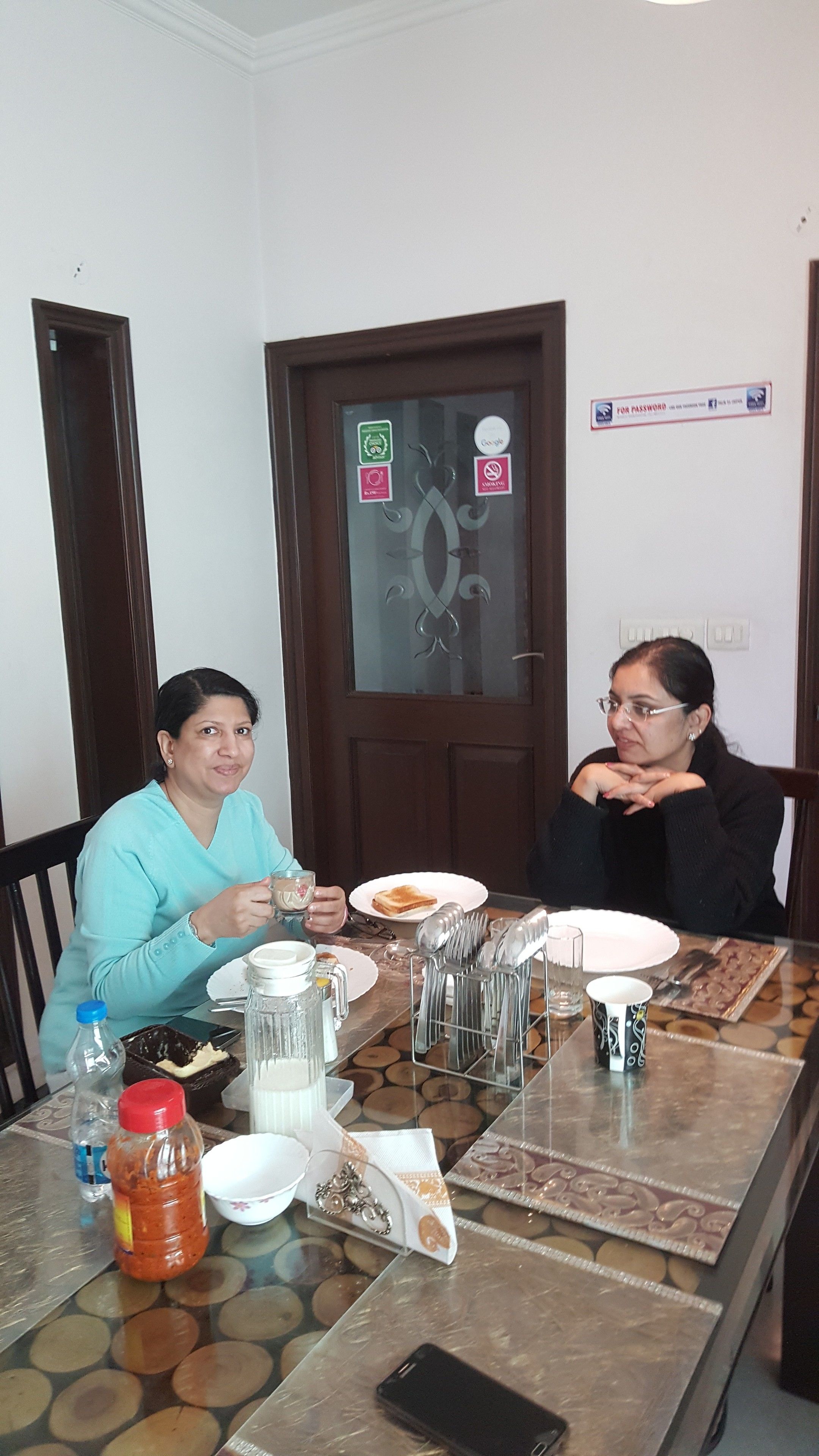 Two people dining at a table with various items including plates, cutlery, and a glass.