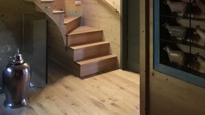 A wooden staircase leading to a second floor, a glass door, and a display of sheep figurines. - Villars sur Ollon Luxury chalet 600m2 (Villars-sur-Ollon)