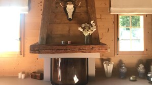 A rustic interior with a wooden ceiling, a deer skull mounted on a wooden shelf, and a vase with white flowers. - Villars sur Ollon Luxury chalet 600m2 (Villars-sur-Ollon)