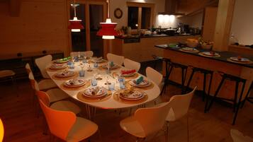 Un coin repas avec une table ronde dressée pour le repas, entourée de chaises.