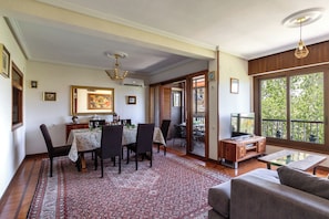 A dining area with a table, chairs, and a patterned rug.