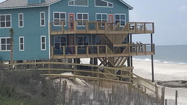 A two-story wooden structure with a balcony, located near a beach. -  Beachfront, Beach Views, Great Location (Port St. Joe)