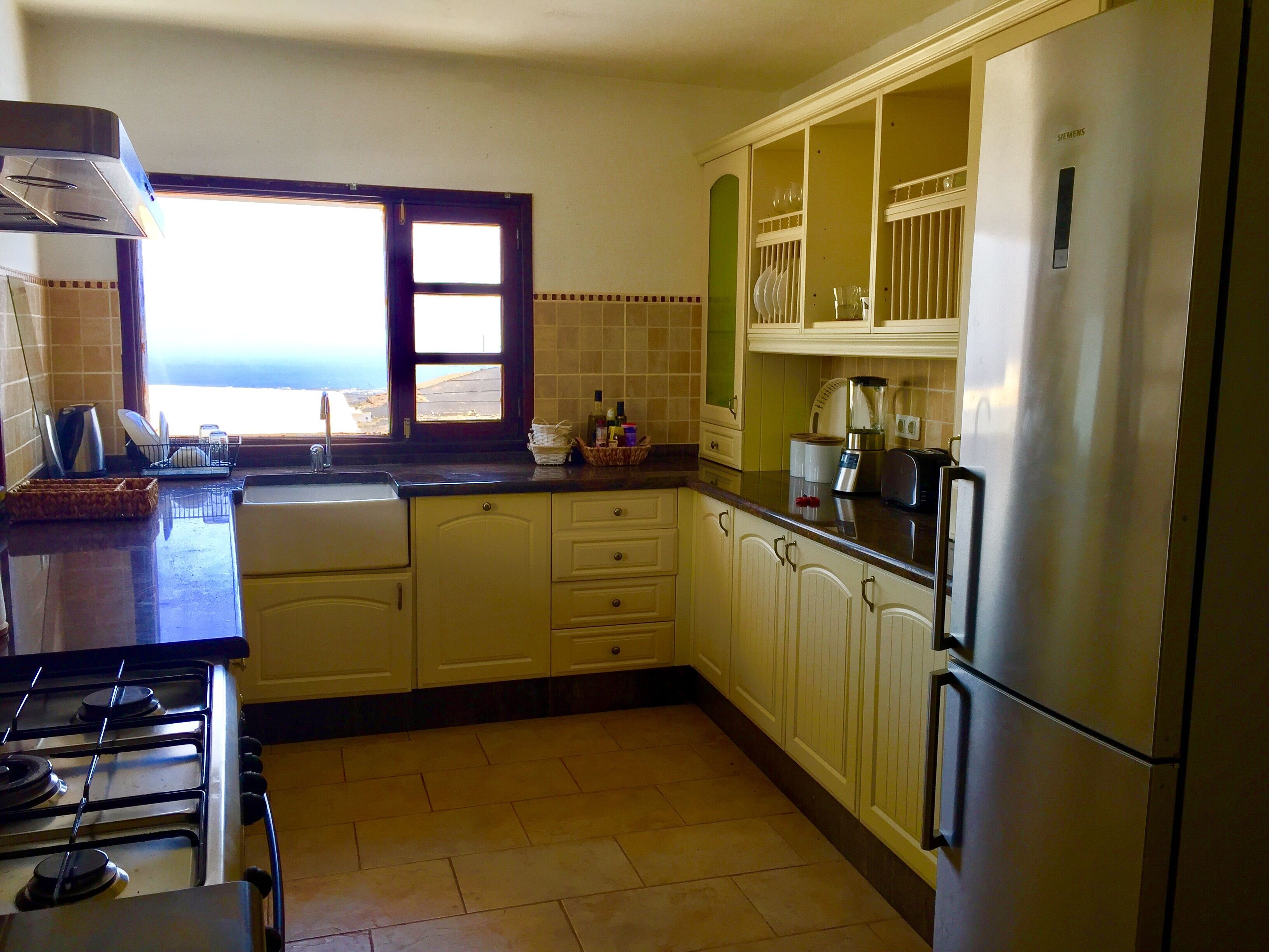 A kitchen with a stove, sink, and refrigerator.