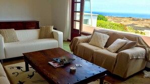 Una sala de estar con dos sofás, una mesa de centro y vistas al océano.