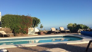 Zona de piscina con sillones de descanso y un cartel que indica prohibido el paso.