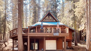 A lodge with a covered deck, a garage, and a sign reading "The Lodge." - Lakeview Capone Getaway, great sledding on property, fun loft for kids, Lg deck (Soda Springs)