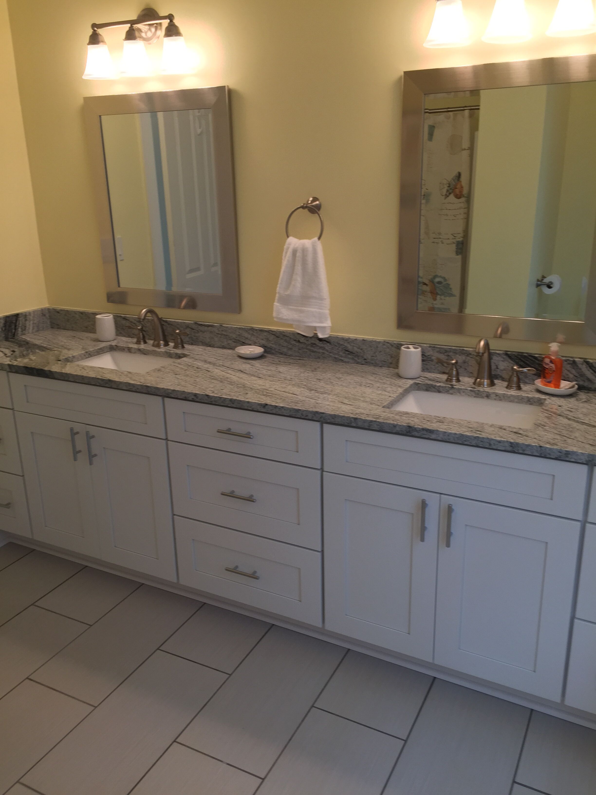 A bathroom with two sinks, a towel rack, and a mirror.