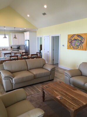 Relax in this stylish living room with a sofa, armchair, and dining area.