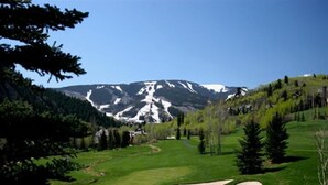 Ein Golfplatz mit freiem Blick auf ein Gebirge im Hintergrund.