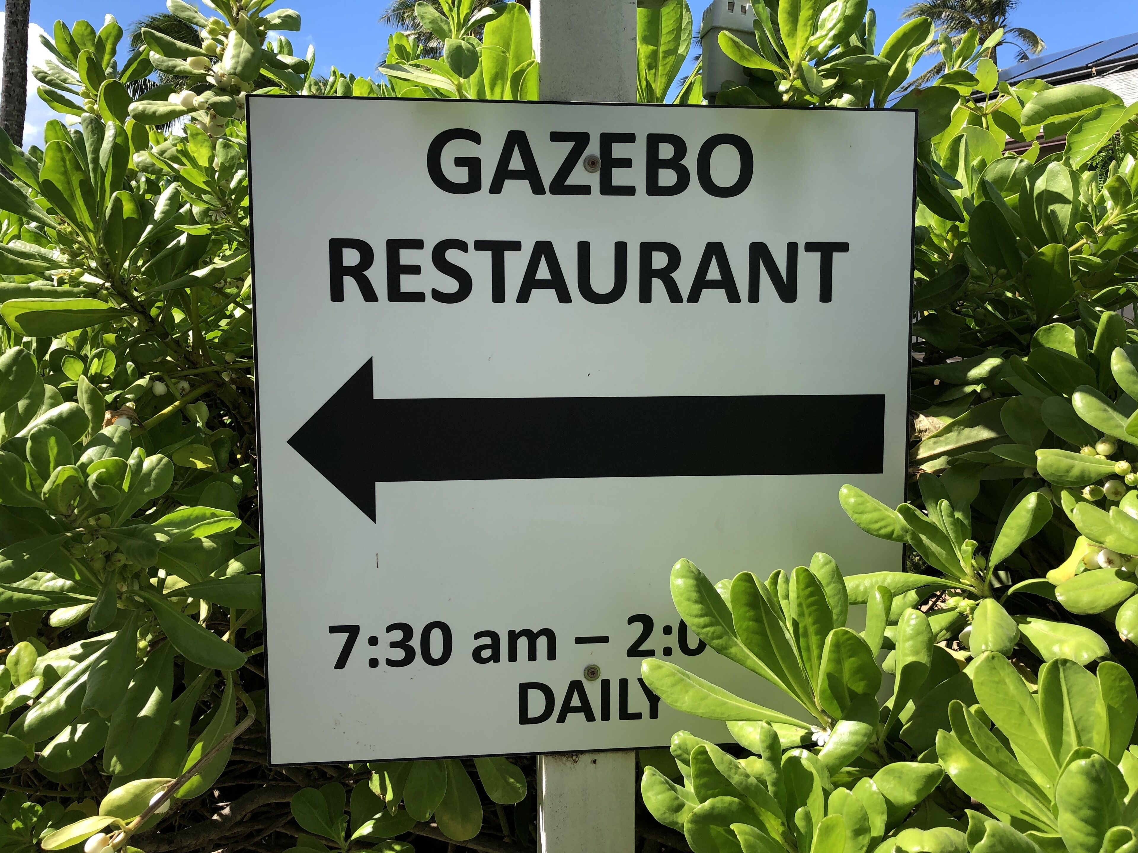 A sign for Gazebo Restaurant with directional arrow and operating hours.