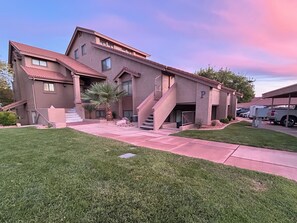 A multi-story building with a red-tiled roof, a central staircase, and a parking area. - St George 1 Bedroom Condo, Sleeps 5, Full Kitchen Sports Village Resort (St George)