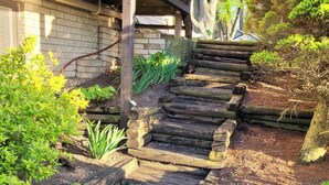 A wooden staircase leading to a building with a brick wall. - Beautiful Waterfront Home on Baugo Bay (Osceola)