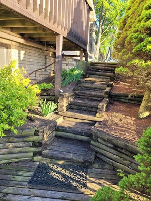 A wooden staircase leading to a building with a brick wall.