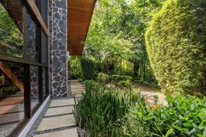 Stroll through the serene garden to the contemporary building with a natural stone facade and large windows.