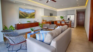 A modern living room with a sofa, chairs, a dining area, and a kitchen. - Designer 2BR w/ Balcony & Pool in Romantic Zone (Puerto Vallarta)