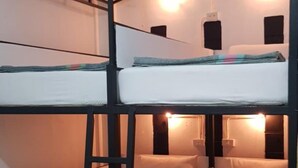 A bunk bed room with a ladder, two bedside tables, and a wall-mounted light fixture. - Om Ganesh Hostel - Adults Only (Ko Pha-ngan)