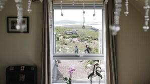 A window with a view of a rocky landscape and a body of water.